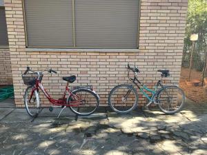 drei Fahrräder stehen neben einer Ziegelmauer. in der Unterkunft La Casa dei Pini in Marina Romea