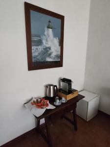 ein Zimmer mit einem Tisch mit einer Kaffeemaschine und einem Bild in der Unterkunft La Casa dei Pini in Marina Romea + 12 Fotos