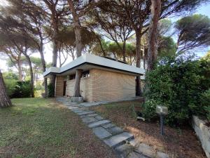 ein kleines Backsteinhaus mit einem Zinndach in der Unterkunft La Casa dei Pini in Marina Romea