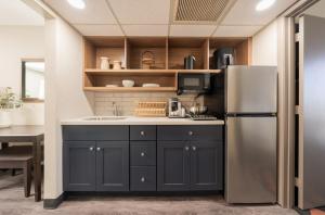 una cocina con frigorífico y fregadero en South Country Suites, en Mesa 8 fotos más