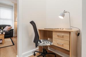 a desk with a chair next to a desk with a lamp at Franks house, 3 Bedroom in Liverpool - sleeps 5, Newly refurbished - long stays welcome, free parking in Litherland