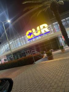 un bâtiment avec un panneau éclairé devant lui dans l'établissement Apartahotel curacao, à Willemstad