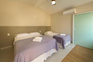 une chambre avec deux lits avec des serviettes dessus dans l'établissement Vila da Praça Pousada, à Capitólio