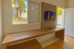 Cette chambre comprend un banc en bois et une fenêtre. dans l'établissement Vila da Praça Pousada, à Capitólio