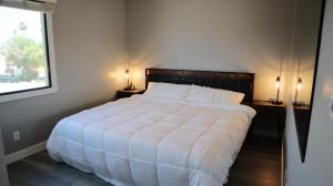 a bedroom with a large white bed with two lamps at Cozy Townhome Close to Old Town in Scottsdale