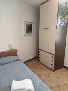 een slaapkamer met een bed en een grote kast bij Da Margherita e Giovanni in Mandello del Lario
