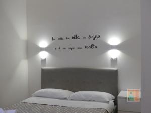 a bedroom with a bed with words on the wall at Alloggio "a casa di Gió" in Tuscania