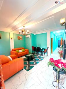 a living room with an orange couch and a table at IKN résidence in Douala