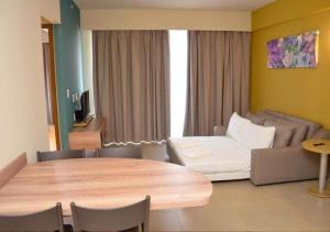 a living room with a table and a couch at Solar das Águas Park Resort in Olímpia