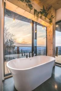 una gran bañera blanca en una habitación con una gran ventana en Tricera - Panoramic View near Quebec City, en Lac-Beauport