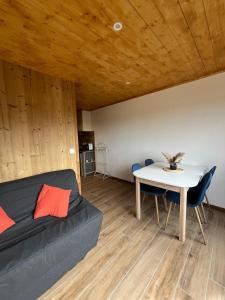 a living room with a couch and a table at Appartement au centre des Carroz in Arâches-la-Frasse +4 photos