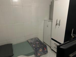 a small room with a bed and a refrigerator at Casa da Amanda in São Thomé das Letras +2 photos