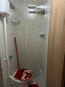 a bathroom with a toilet with a red lid at Casa da Amanda in São Thomé das Letras
