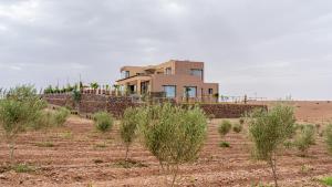 a house in the middle of a field with trees at Life resort Marrakech 