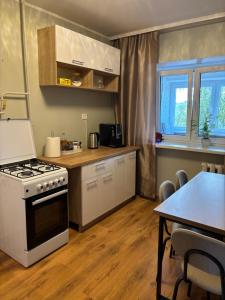 a kitchen with a stove and a table in it at Pikk street Apartment in Tartu