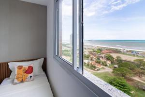 1 Schlafzimmer mit einem Fenster mit Blick auf den Strand in der Unterkunft 15 Andar, 2Q Suite Vista Mar, Ed Palmer, NOMDS in Insel Itaparica