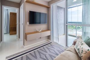 ein Wohnzimmer mit Fernseher und Sofa in der Unterkunft 15 Andar, 2Q Suite Vista Mar, Ed Palmer, NOMDS in Insel Itaparica