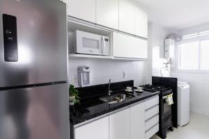 eine Küche mit einem Kühlschrank aus Edelstahl und einer Spüle in der Unterkunft 15 Andar, 2Q Suite Vista Mar, Ed Palmer, NOMDS in Insel Itaparica
