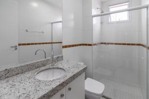 ein weißes Badezimmer mit Waschbecken und Toilette in der Unterkunft 15 Andar, 2Q Suite Vista Mar, Ed Palmer, NOMDS in Insel Itaparica + 16 Fotos