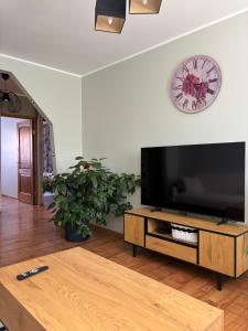 a living room with a large television and a clock on the wall at Pikk street Apartment in Tartu