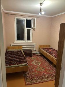 an empty room with two beds and a window at Սեփական տուն in Vanadzor