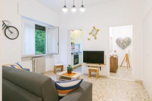 a living room with a couch and a television at Pichouse Brianza Varedo in Bovísio-Masciago Milanese
