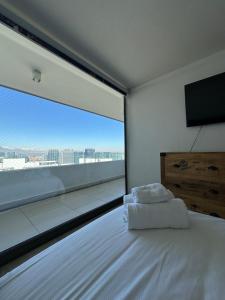 a bedroom with a bed with a large window at Matías Plaza in Santiago +20 photos