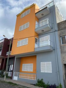 een oranje gebouw met witte ramen en balkons bij Casa Melissa in Ponta do Sol