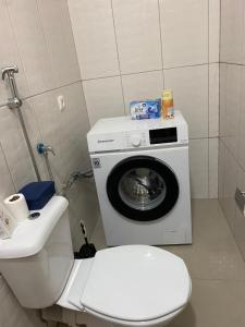 een badkamer met een wasmachine naast een toilet bij Casa Melissa in Ponta do Sol