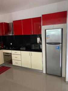 een keuken met rode kasten en een roestvrijstalen koelkast bij Casa Melissa in Ponta do Sol