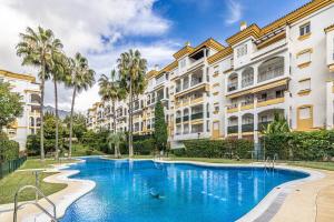 a swimming pool in front of some apartment buildings at Apartamento Costa Nagüeles 2hab. in Marbella