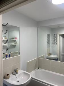 ウォルヴァーハンプトンにあるWilsuel homestayの浴槽と洗面台のある白いバスルーム