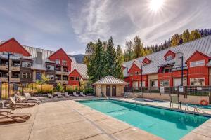 a pool in the courtyard of a apartment complex with red buildings at Lake Placid Lodge 126 in Whistler