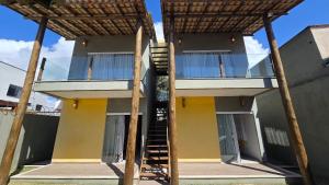 a building with a staircase on the side of it at Casa Temporada Brisa do Mar in Guriri