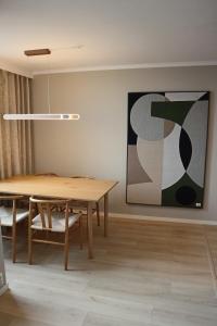 モルデにあるApartment in Moldeの木製テーブルと絵画のあるダイニングルーム