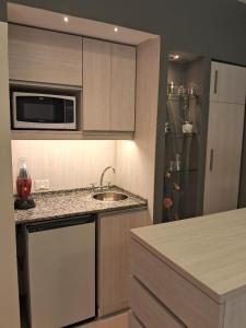 a kitchen with a sink and a microwave at Torre Esmeralda 740 in Buenos Aires
