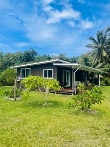 una piccola casa con un cortile verde di 2 Bedroom House - Villa Teremoana a Ngatangiia