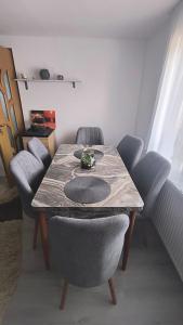 een eettafel met 4 stoelen en een tafel met bij Casa Bianchi Vatra Dornei in Vatra Dornei