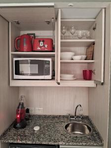 a kitchen with a sink and a microwave at Torre Esmeralda 740 in Buenos Aires