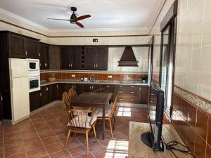 eine Küche mit einem Tisch und Stühlen sowie einem Deckenventilator in der Unterkunft Casa Indalo in La Puebla de los Infantes