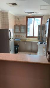 a kitchen with a counter top and a refrigerator at دره العروس فيلا الروز للعائلات in Durat Alarous +8 photos