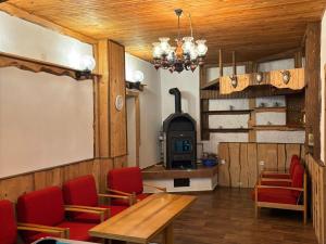 a room with a table and chairs and a wood stove at Chalupa Bonanza in Jívka