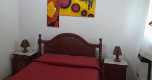ein Schlafzimmer mit einem roten Bett mit zwei Nachttischen in der Unterkunft Cabañas La Petunia in Santa Rosa de Calamuchita + 12 Fotos