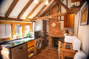 a kitchen with a sink and a stove top oven at Ye Olde Cottage in Crawley