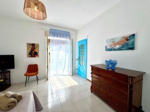 a living room with a dresser and a blue door at Dipinto di Blu in Aci Castello