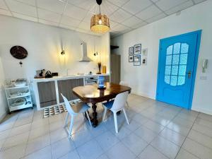 a kitchen with a table and chairs and a blue door at Dipinto di Blu - Faraglioni Seaside Retreat in Aci Castello