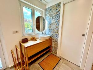 a bathroom with a sink and a mirror and a window at Dipinto di Blu in Aci Castello +30 photos