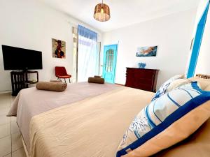 a bedroom with a large bed and a flat screen tv at Dipinto di Blu - Faraglioni Seaside Retreat in Aci Castello