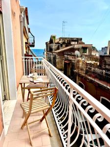 a balcony with two tables and a view of the ocean at Dipinto di Blu in Aci Castello