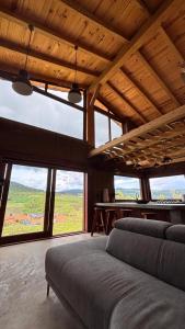 a living room with two couches and large windows at Cabaña Alua in Ferrería de Tula